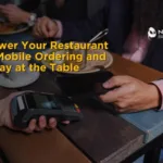 "Diner holding a credit card near a restaurant's POS payment terminal at a table, with overlaid text reading 'Empower Your Restaurant with Mobile Ordering and Pay-at-the-Table Technology'"