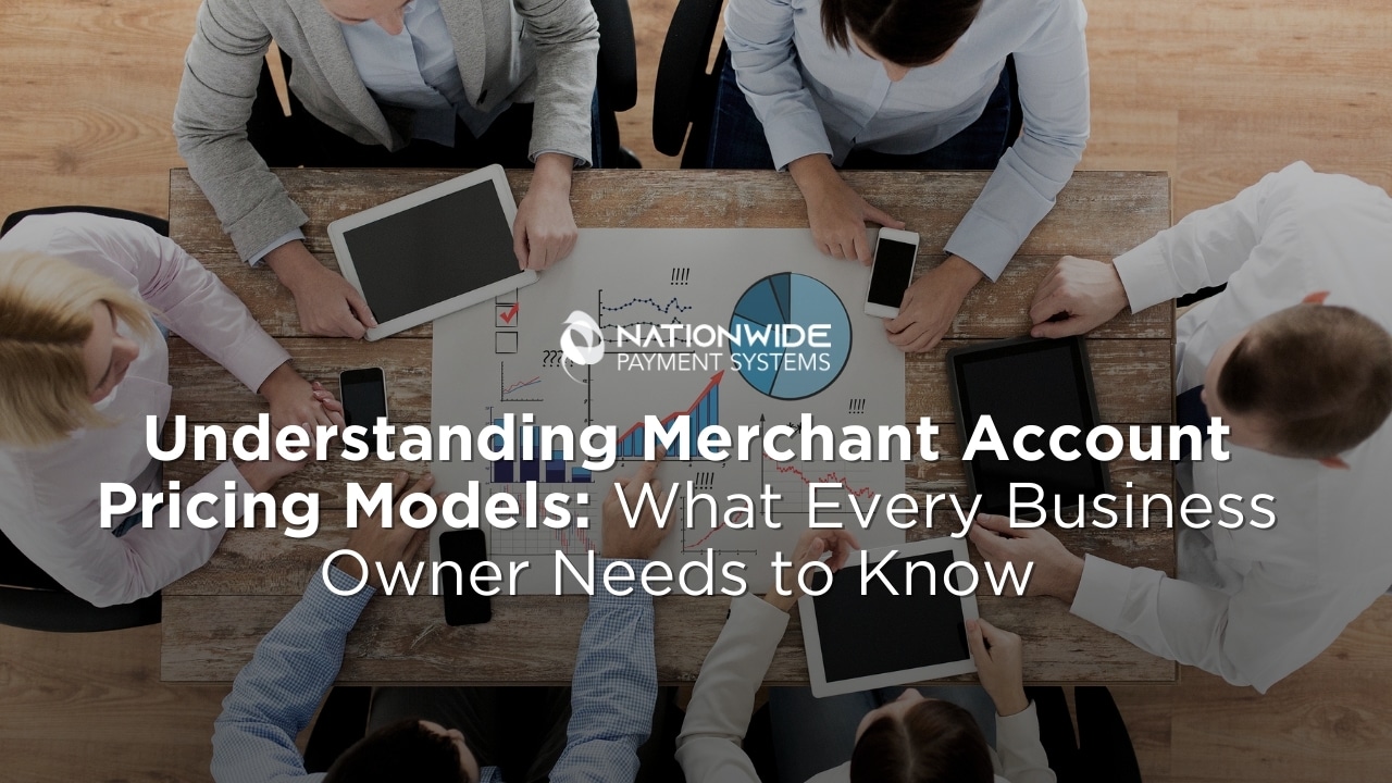 Group of business professionals analyzing merchant account pricing models with charts and devices on a table.