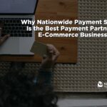 An overhead, bird's-eye view of an entrepreneur sitting at a wooden desk on a woven rug, working on a silver laptop. One hand rests on the laptop keyboard while the other holds a gold Visa credit card, preparing to input payment details. Bold white text overlays the center reading "Why Nationwide Payment Systems Is the Best Payment Partner for E-Commerce Businesses," with the white corporate logo positioned in the lower right corner.
