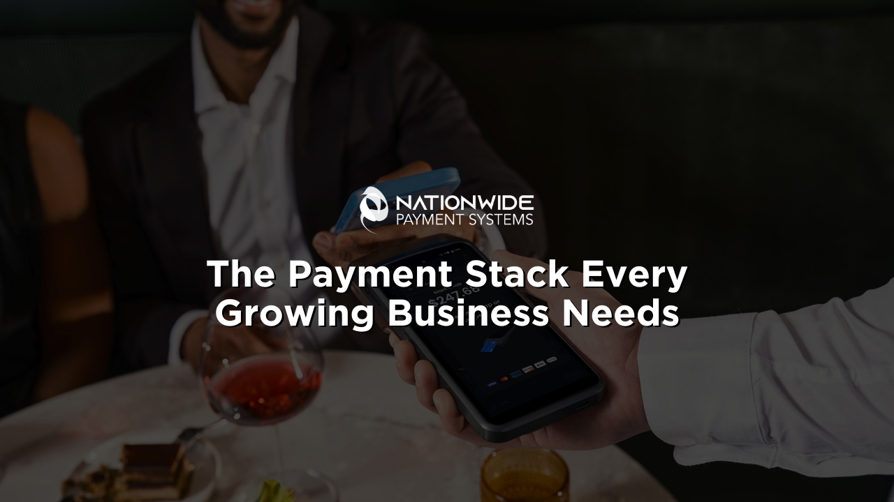 A close-up photograph of a server holding out a modern, dark hand-held smart POS payment terminal. A customer in a dark suit jacket holding a blue smartphone hovers their device over the screen to complete a contactless NFC mobile wallet transaction [cite: The Payment Stack Every Growing Business Needs (1).jpg]. In the background, a dining table features a glass of red wine, a desert plate, and a warm-colored drink [cite: The Payment Stack Every Growing Business Needs (1).jpg]. Centered in the middle of the image is the white Nationwide Payment Systems logo above bold white overlay text that reads: "The Payment Stack Every Growing Business Needs"