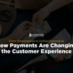 An overhead view of a physical cash exchange taking place above a desk. One person hands cash to another individual who is holding a printed paper receipt. Centered on top of the image is the Nationwide Payment Systems logo with yellow and white text reading "From Omnichannel to Unified Commerce: How Payments Are Changing the Customer Experience."