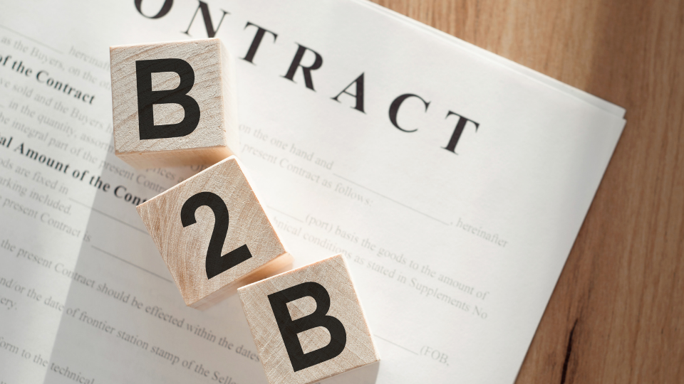 B2B Payment Optimization Smart Invoicing NPSONE Wooden letter blocks spelling B2B arranged diagonally over a business contract document on a wooden desk.